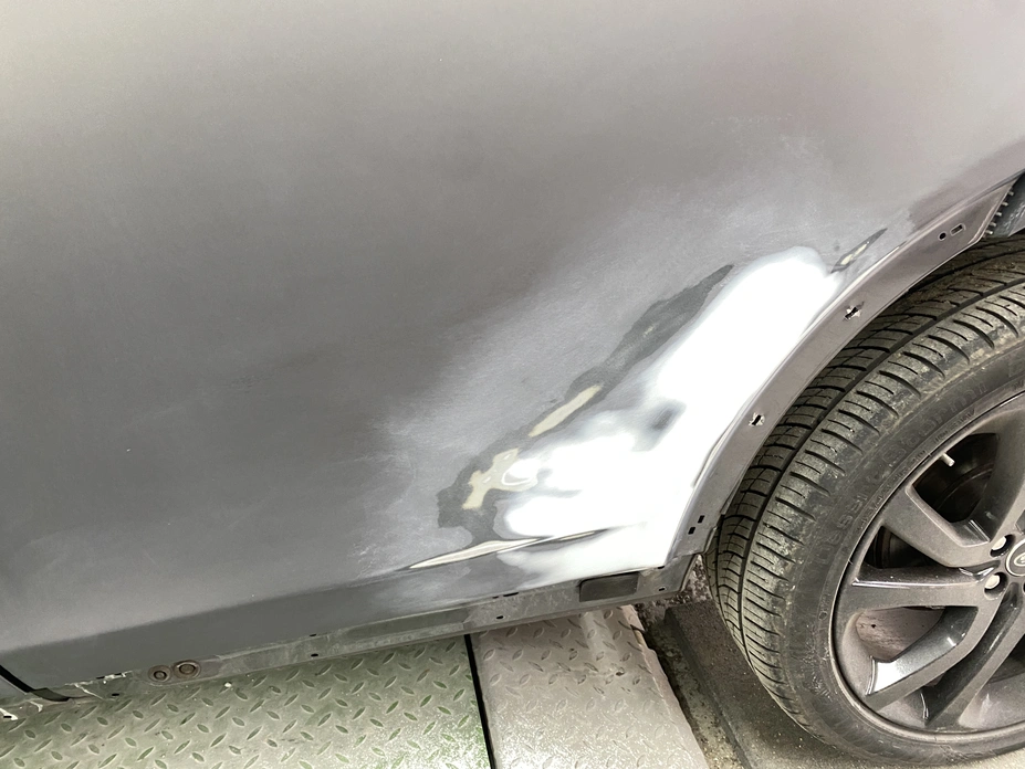 Close-up of a car with a partially repaired dent on the side